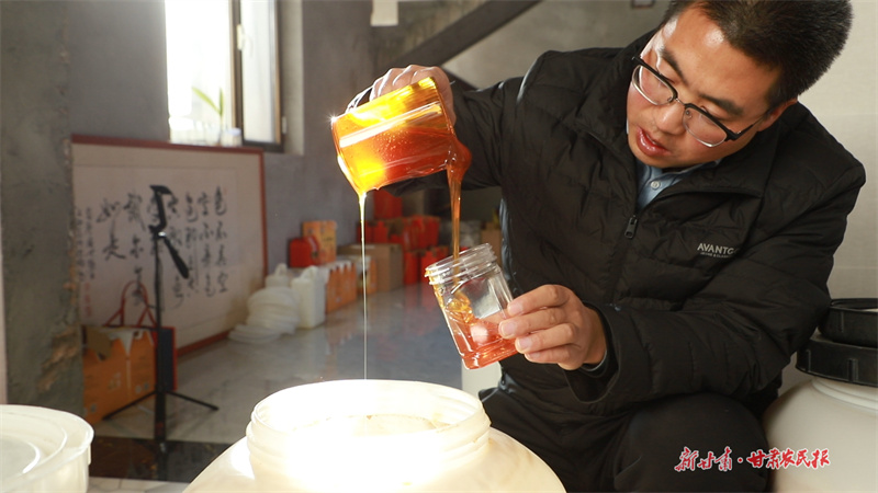 王彥奇正在灌裝蜂蜜。 邵娟青 攝